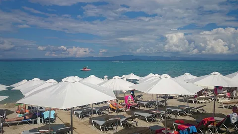 Beach umbrellas by the sea in Chaniotis